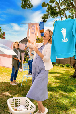 junge frau hängt wäsche auf im sommerlichen Garten, Marketingmotiv Finanzdienstleister 