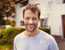 man mit farbklecks auf der nase und im gesicht lächelt in die kamera, Marketingmotiv Finanzdienstleister, Fotograf Jens Ihnken 