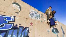 junges dynamisches teenager paar sitzt auf betonmauer die mit grafitty besprüht ist, Marketingmotiv Finanzdienstleister, Fotograf Jens Ihnken 